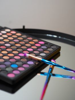 A colorful array of makeup shades with brushes reflected on a mirror in Paris.