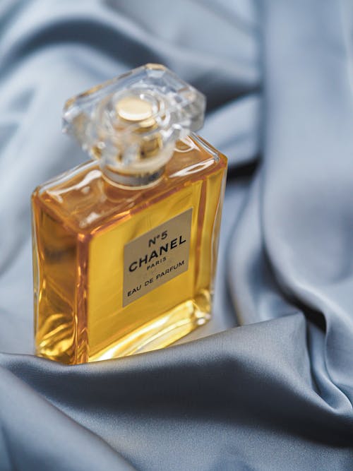 A bottle of chanel perfume sitting on a blue cloth