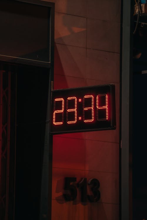 A red digital clock on a building