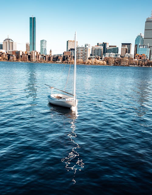 A sailboat in the water near a city skyline