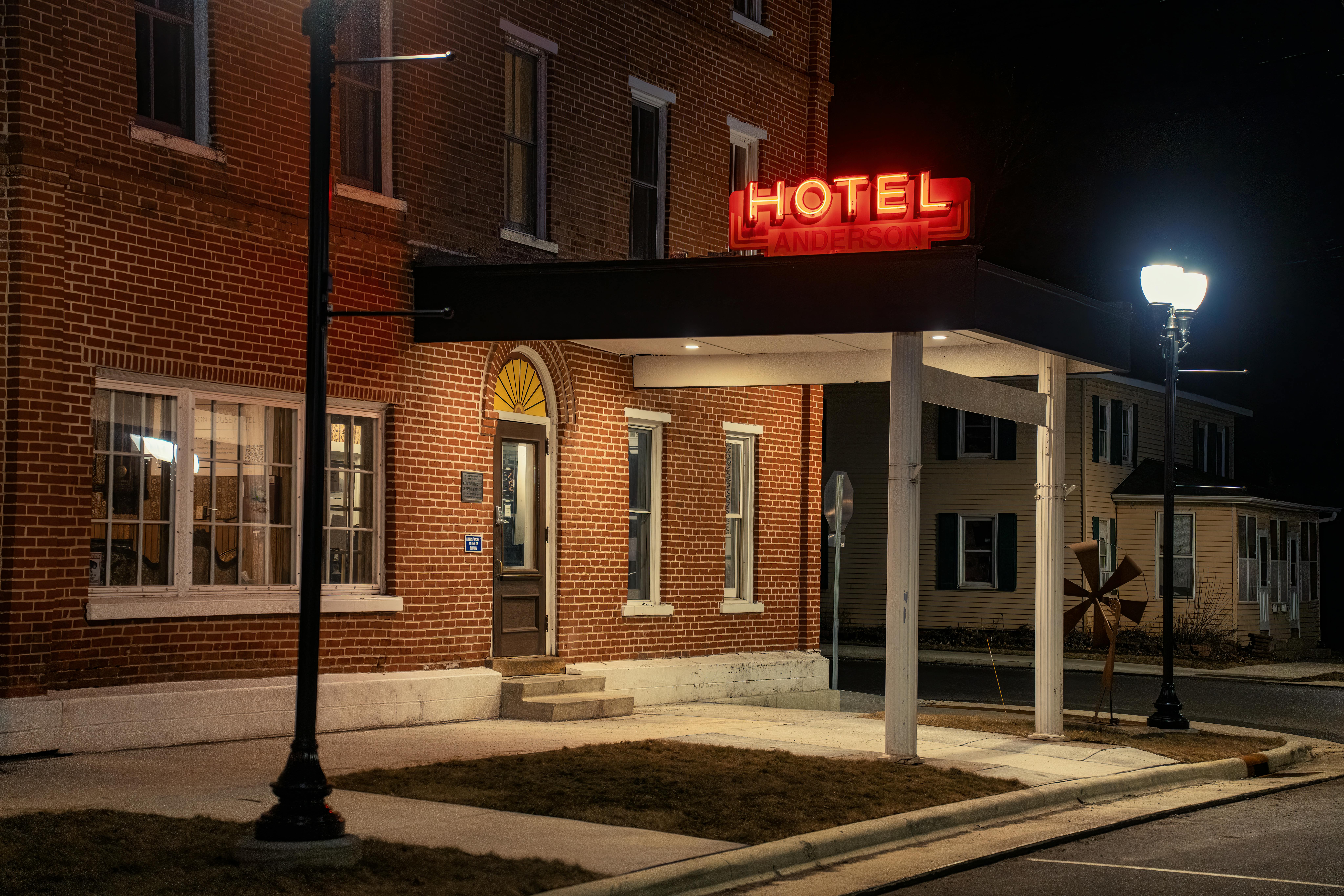 Brick exterior of Anderson Hotel in Wabasha, MN at night with illuminated signage.