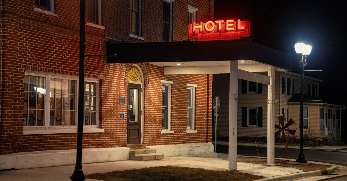 Brick exterior of Anderson Hotel in Wabasha, MN at night with illuminated signage.