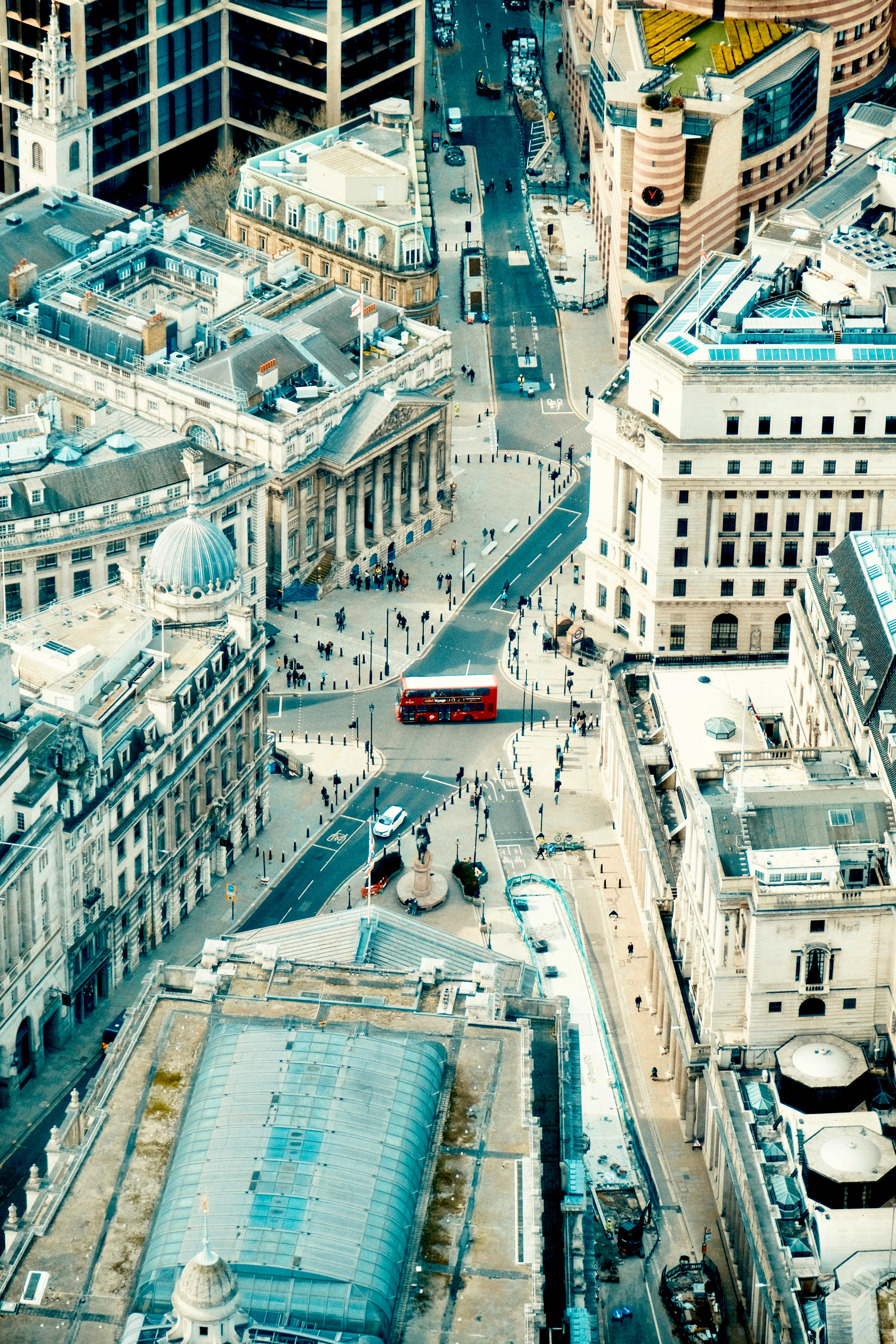 A stunning aerial view of London's urban streets with a prominent red bus in the cityscape.