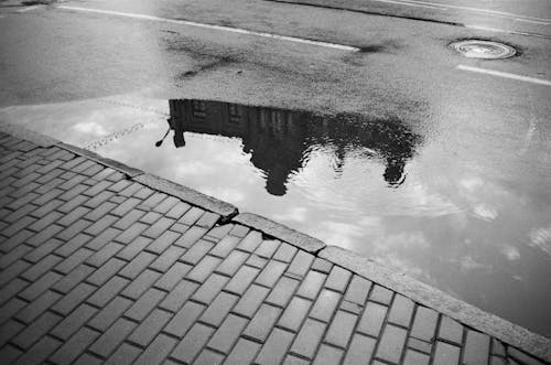 A black and white photo of a puddle on the street