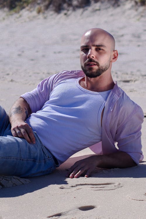 Free A Bald, Bearded Man Posing on a Beach  Stock Photo