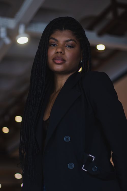 Free Portrait of a confident woman in a black jacket, showcasing elegance and modern style. Stock Photo