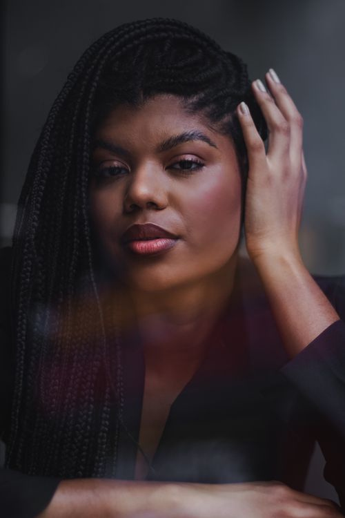 Free Stunning close-up portrait of a woman with braided hair in a serene expression. Stock Photo