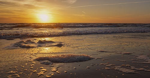 Free Scenic View of Waves Washing Up the Beach at Sunset Stock Photo