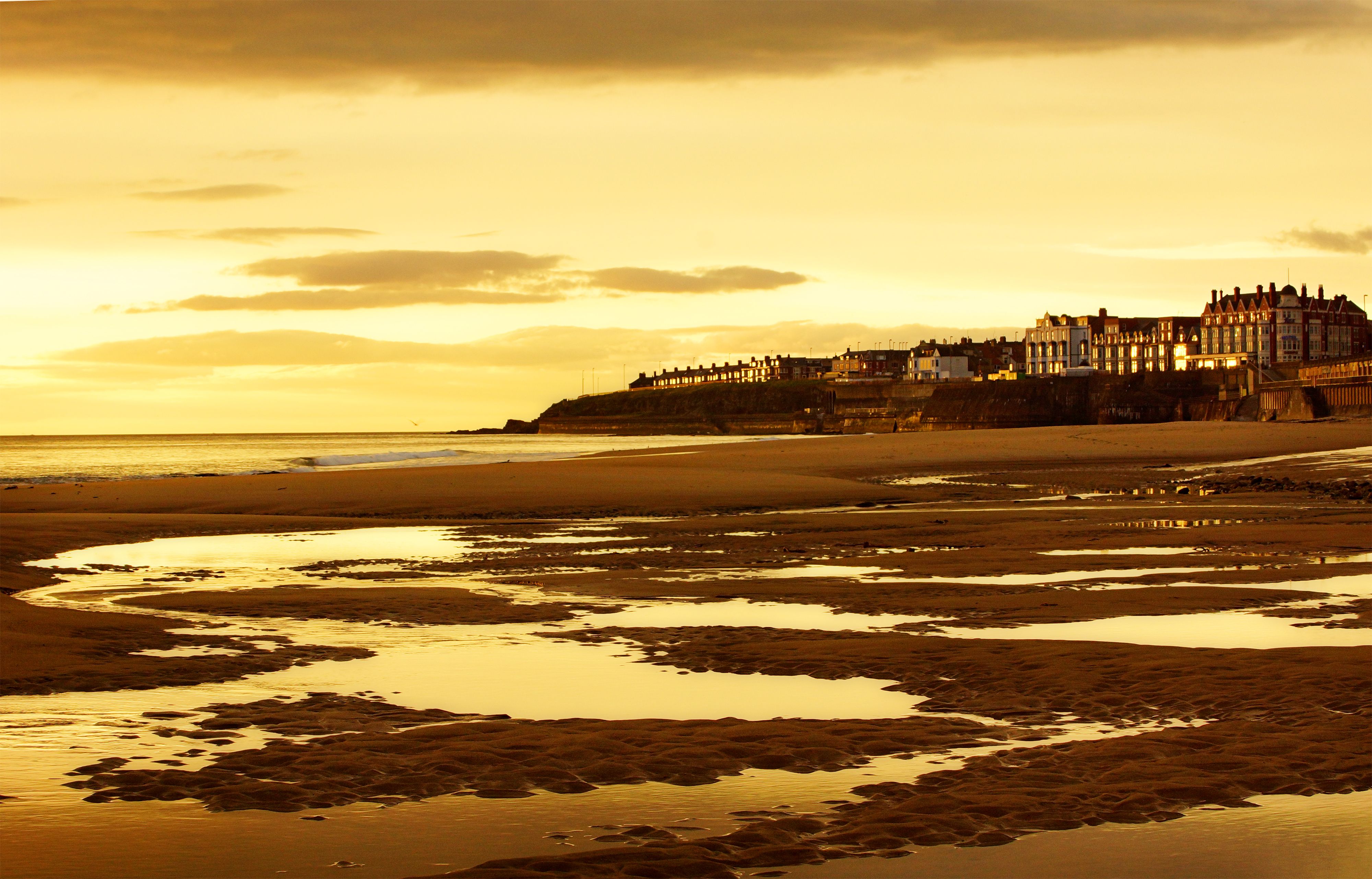 Serene sunset over Whitley Bay beach with stunning waterfront architecture.