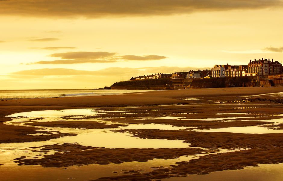 Serene sunset over Whitley Bay beach with stunning waterfront architecture.