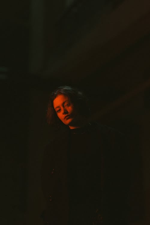 A man in black jacket standing in the dark