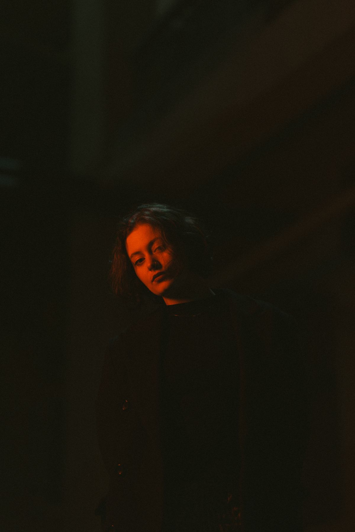 A face illuminated by cinematic red light. Atmospheric photographic reference, not a film still.