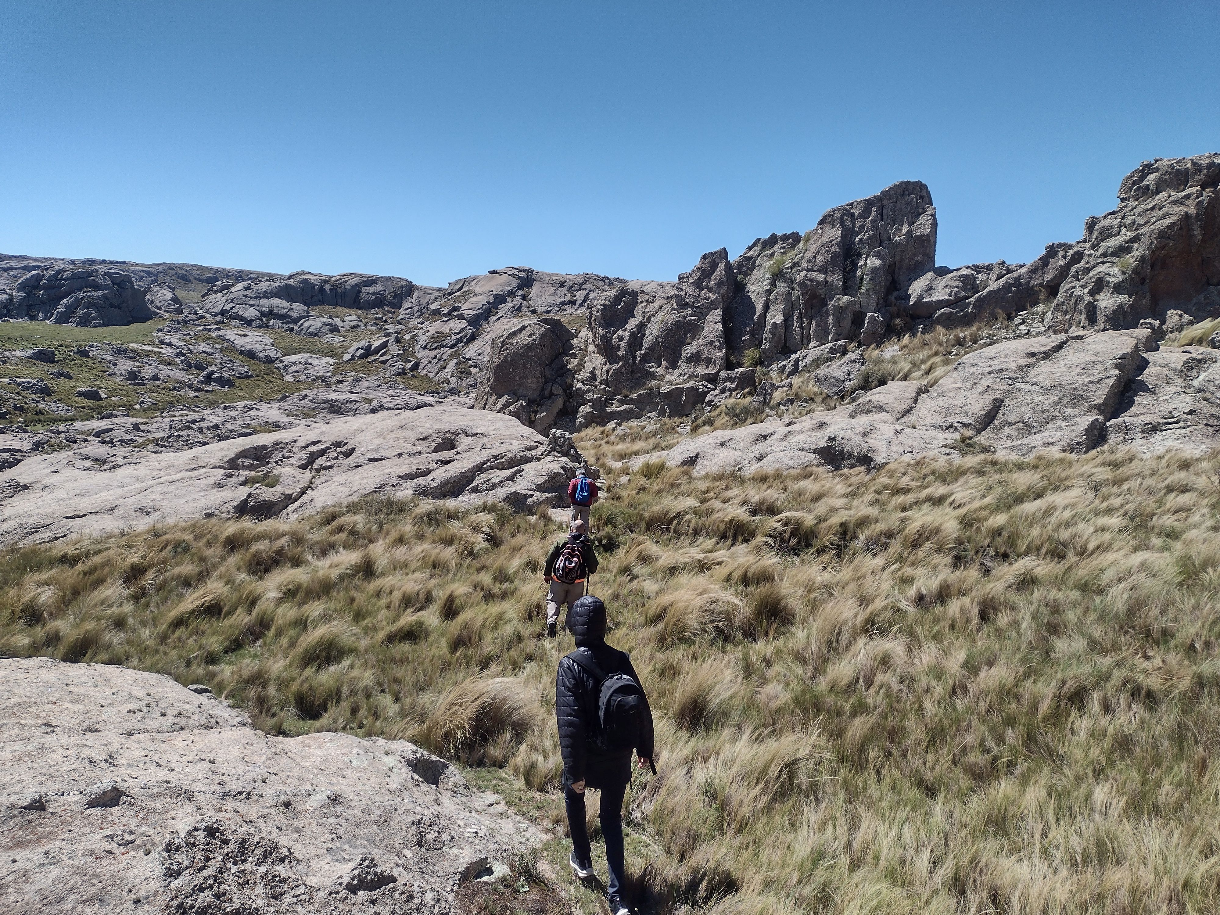 South Georgia Spring Photo Tour: Capture Nature's Wonders - Group of hikers walking on a rocky mountain trail on a sunny day.