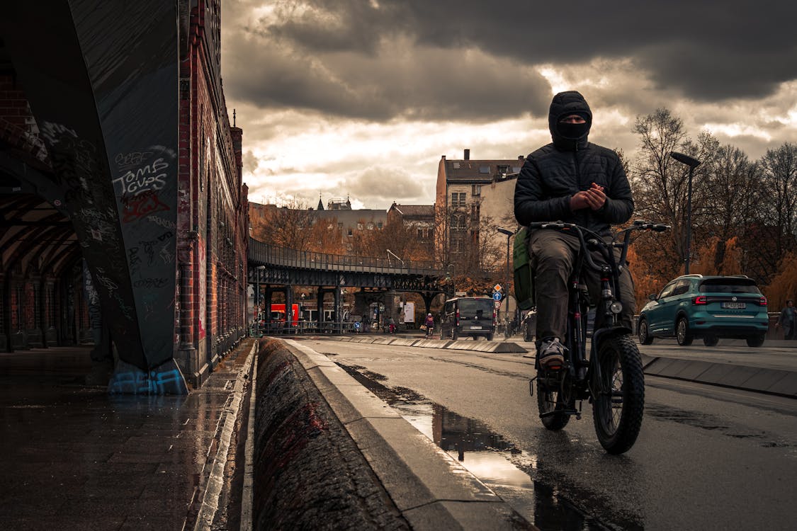 A man riding a bike on a rainy day