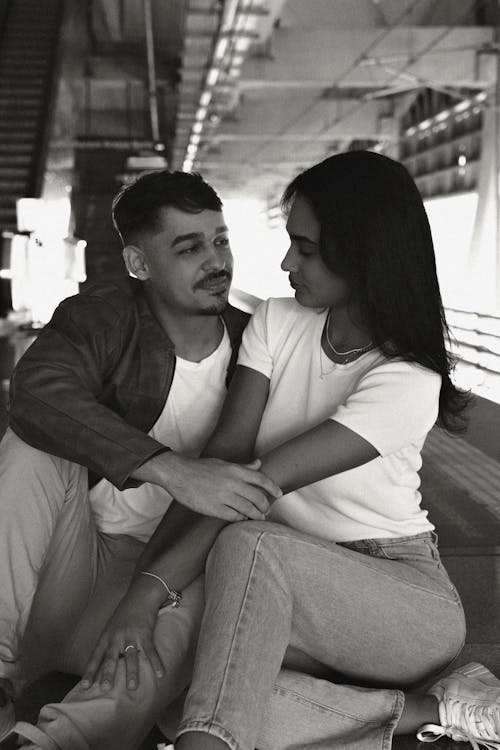 Free A black and white photo of a couple sitting on a bench Stock Photo