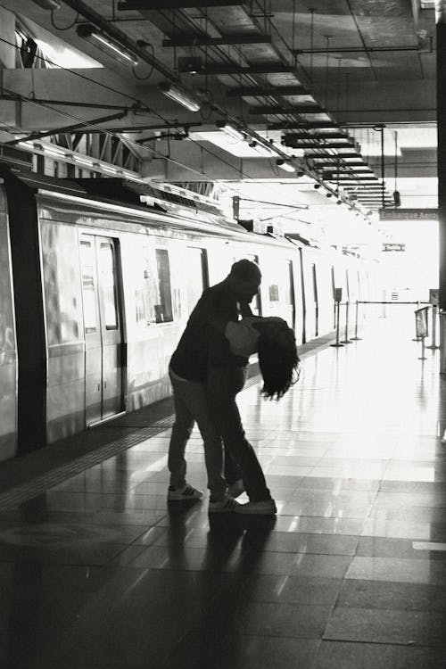 A couple kissing in a subway station