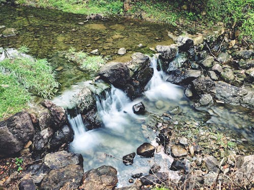 A small waterfall in the woods with rocks