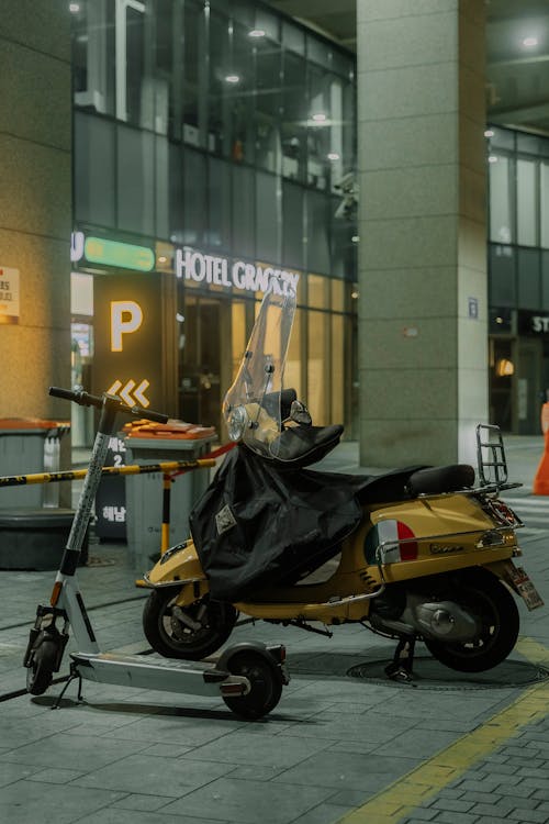 A yellow scooter parked in front of a building