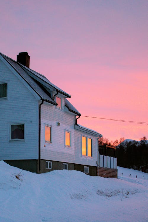 A house is shown in the snow at sunset