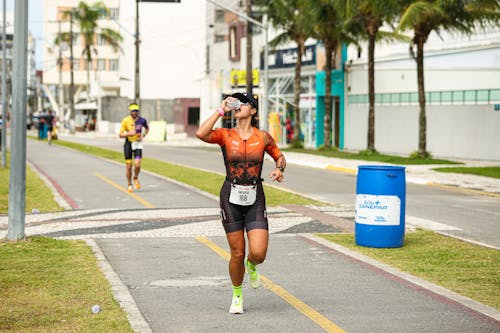 A man in a triathlon outfit running down a road