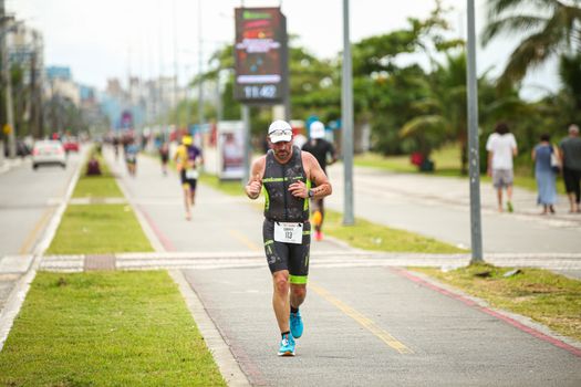 Athlete running a marathon on a city street, showcasing fitness and determination.