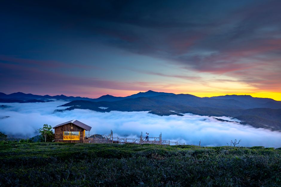 Peaceful sunrise view of a wooden cabin amidst the mountain mist in Đà Lạt.