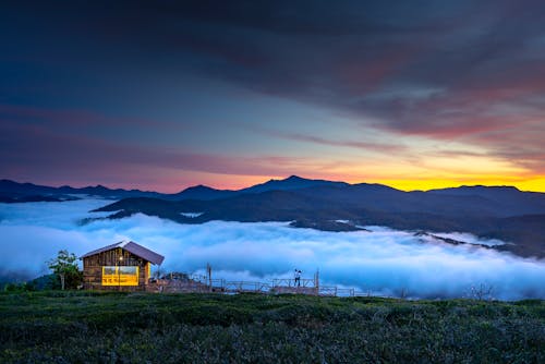 구름과 산을 볼 수있는 갈색 목조 별장