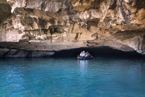 People on Boat Under Cave