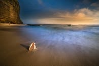 日落时，沙滩和悬崖上有贝壳，宁静的海滩景色