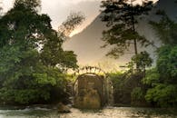 宁静的水轮景色在郁郁葱葱的绿意和黎明的山峦间，展现了大自然的和谐