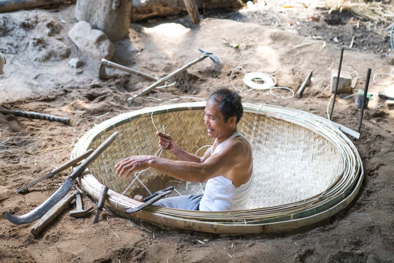 Cow eating from trough while farmer observes