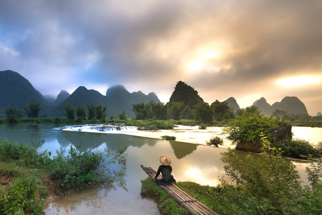 Gratis lagerfoto af asiatisk person, bambus båd, bjerge