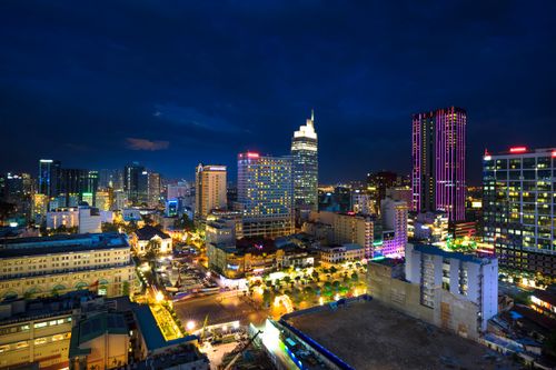 Free Dazzling evening cityscape featuring colorful high rises and luminous city lights. Stock Photo