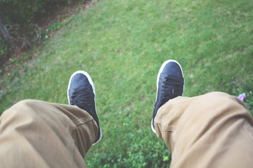 Kahverengi Pantolon Ve Siyah Beyaz Ayakkabı Giyen Kişi