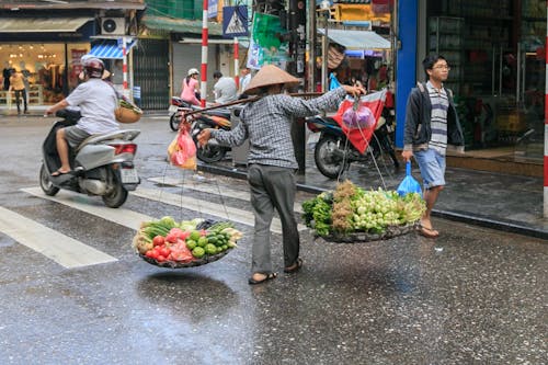 Free Person Carrying Vegetables Passing on Road Stock Photo