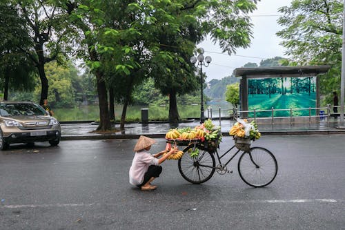 Persona Sentada Cerca De Bicicleta Con Frutas