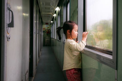 Foto Gadis Berdiri Di Dekat Jendela Di Lorong Kereta Melihat Ke Luar Saat Mengambil Foto