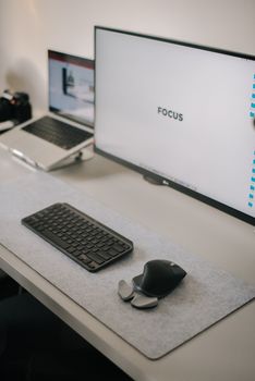 Clean home office with dual monitors, keyboard, and mouse for productivity-focused work environment.