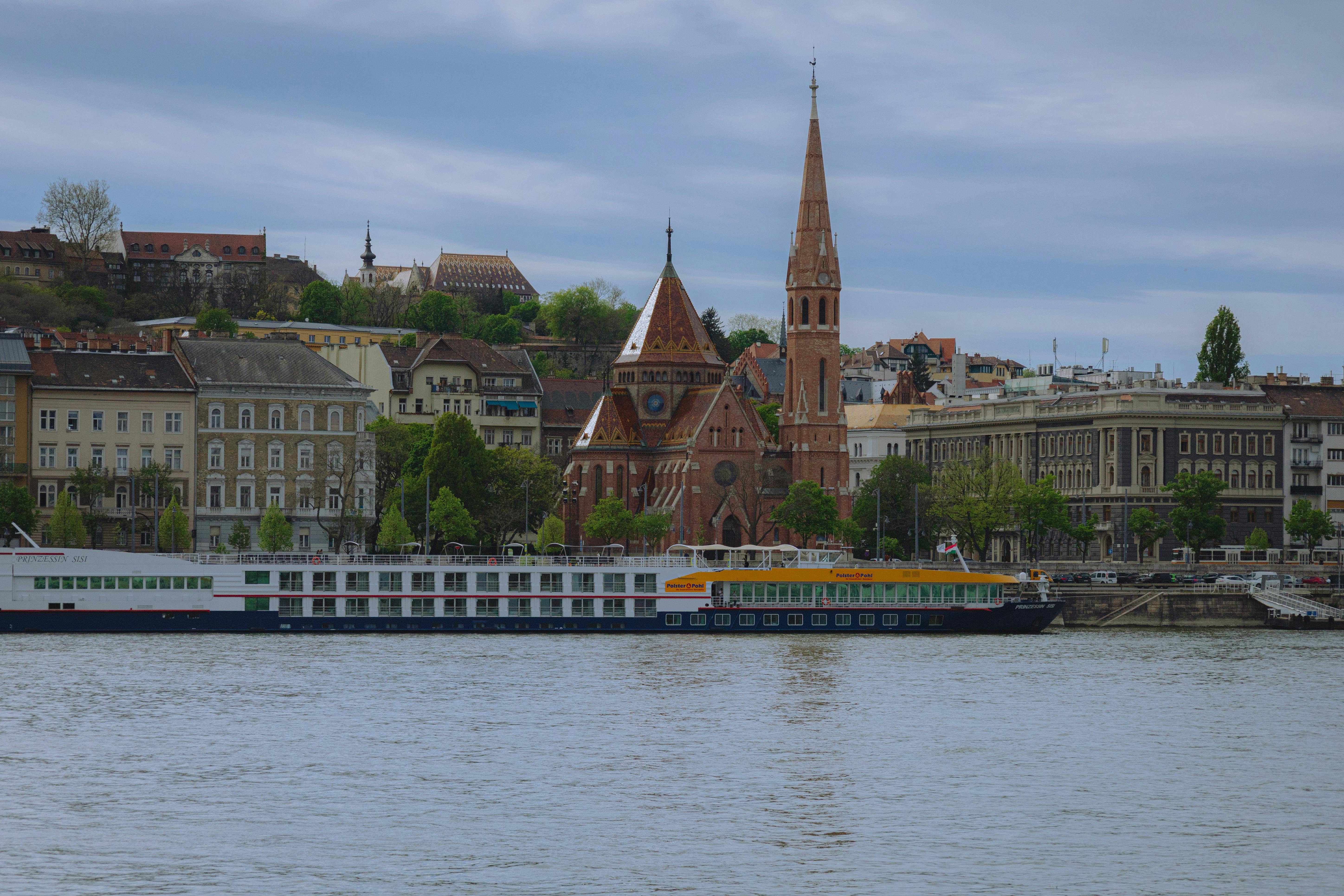 Picturesque view of Budapest's waterfront with historic buildings and a river cruise ship.