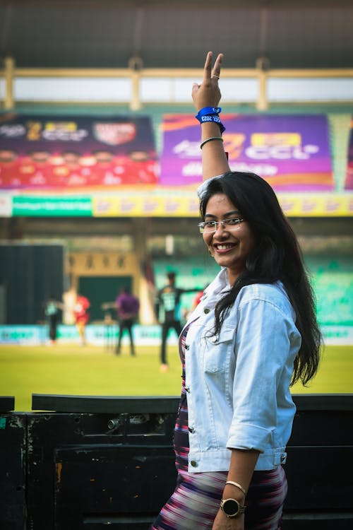 A woman in a stadium waving her hand