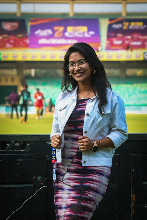 A woman in a dress standing in front of a stadium