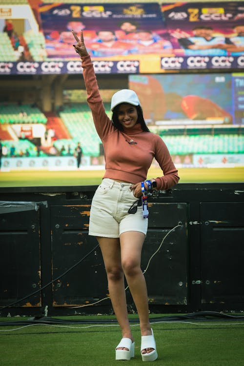 A woman in shorts and top waving at the camera