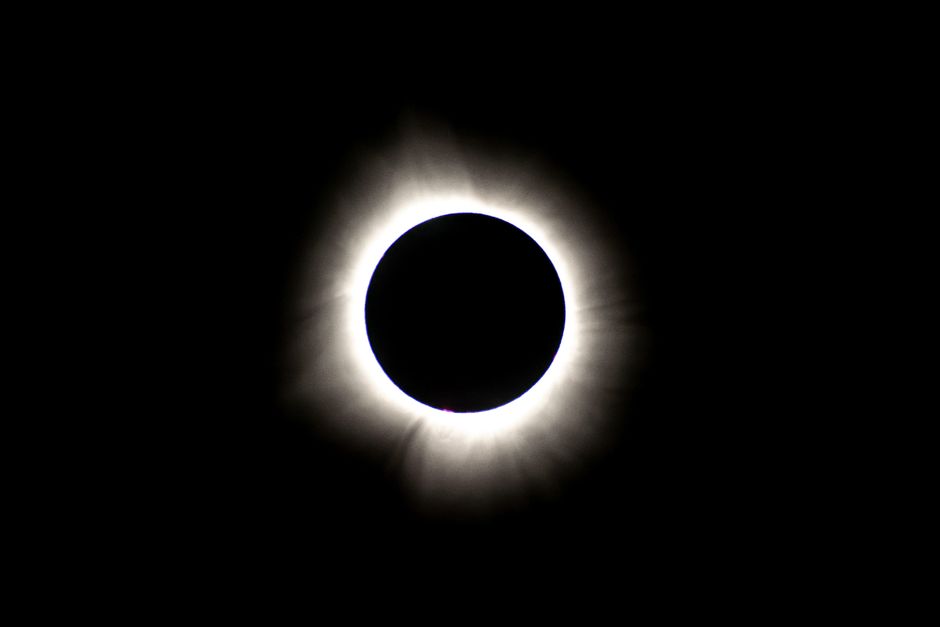 Fotomural Impresionante imagen de un eclipse solar total con la corona visible en un cielo oscuro y claro.