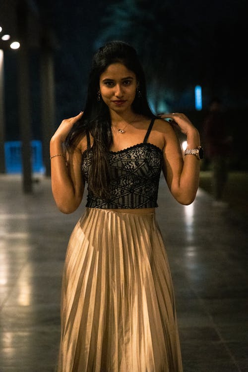 A woman in a gold skirt and black top