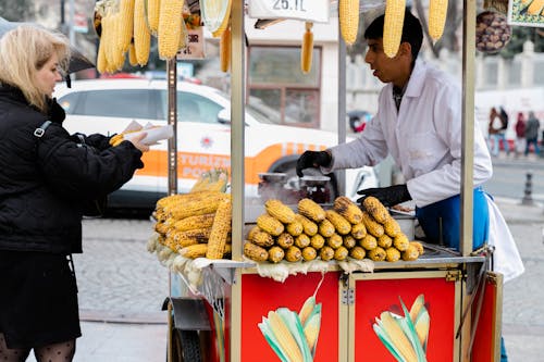 A woman selling corn on a street corner