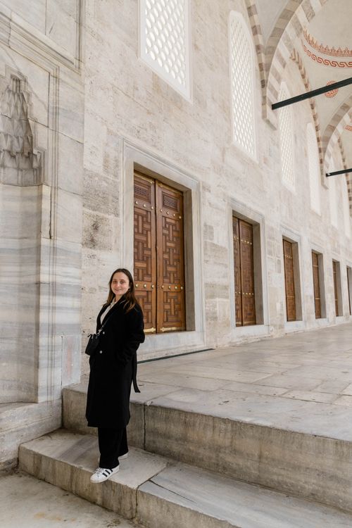 Free A woman standing in front of an Ottoman mosque's architectural facade in Istanbul, Turkey. Stock Photo