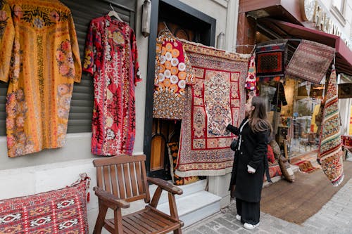 A woman looking at a shop with rugs on display