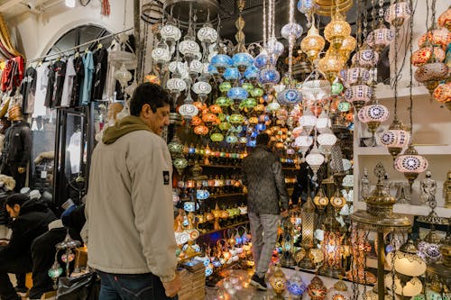 A man is looking at a display of colorful lamps