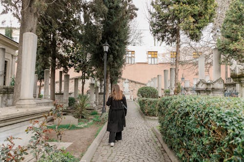 A woman walking down a path in a cemetery