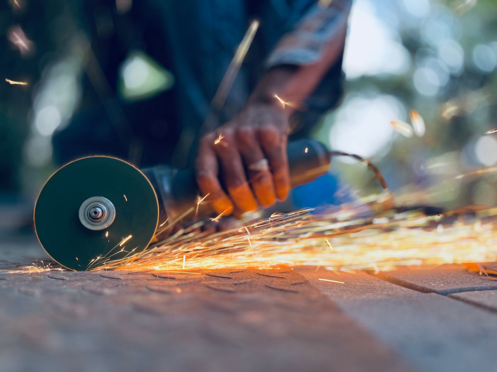 Buying vs Renting Power Tools at Home Depot: A Practical Guide Dynamic shot of a man using an angle grinder with sparks flying. Perfect for industrial themes.